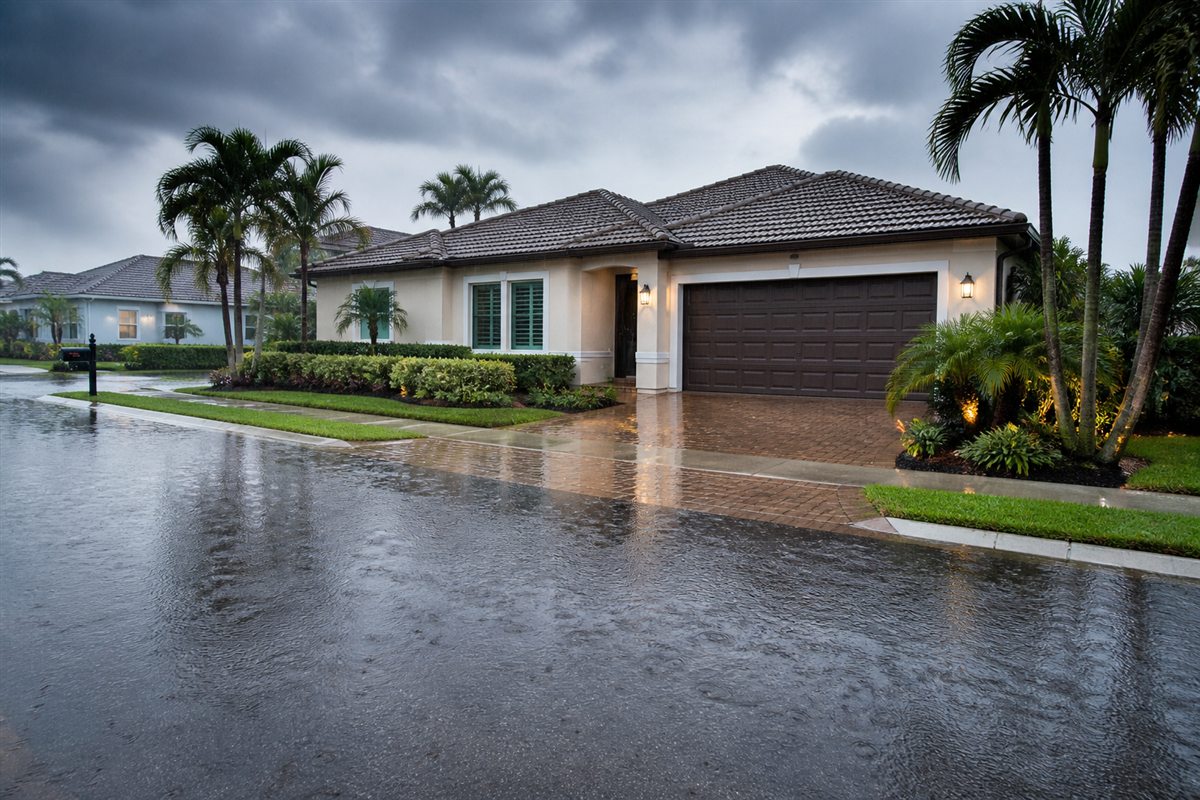 Florida home during heavy rain with standing water along the residential street